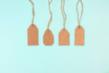 Kahverengi kraft kağıt etiketleri ve mavi arka planda jüt halatı. Fiyat etiketi. İndirim konsepti. Uzayı kopyala, düz yat