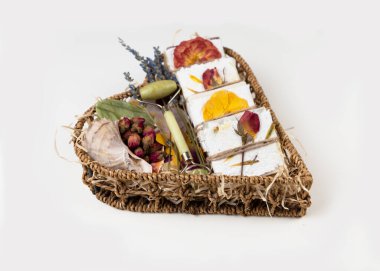 Doğal ev yapımı sabun, organik kurutulmuş gül yapraklarıyla el yapımı sıkıştırılmış çiçek kağıdına sarılı kalp şeklinde bir sepetin içinde yatıyor. Etik, sürdürülebilir, sıfır atık yaşam tarzı. Şirket ya da kişisel hediye fikri. Kadınlar için hediye, sevgililer günü, anneler günü.