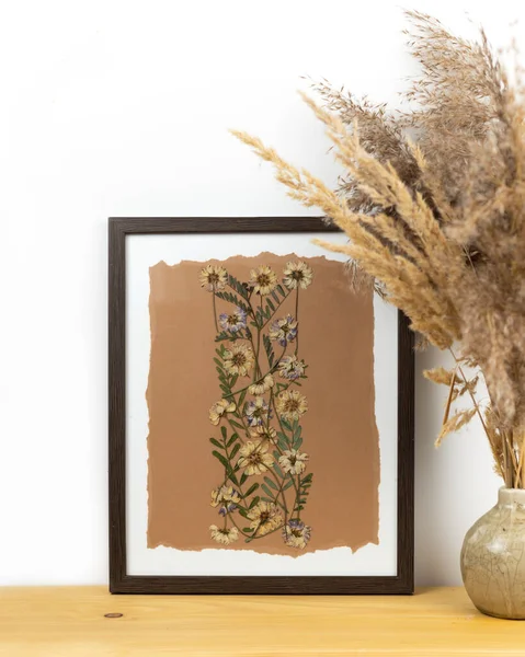 Oshibana floristry botanical pressed flower art. Composition of dry plants. Dried wildflowers frame on beige background. Contemporary botanical art.