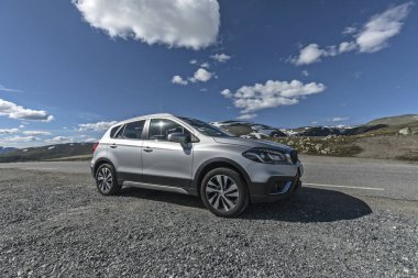 Kar Yolu, Norveç - 29 Temmuz 2022 Kiralık Suzuki S-Cross Hibrit araba Aurlandsfjellet 'te karlı bir yolda bir dağ geçidi üzerinde 