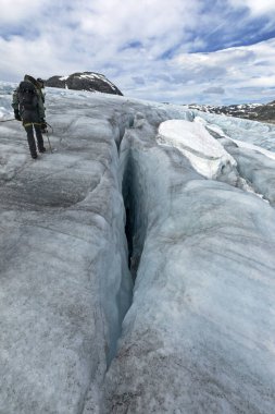 Jostedalsbreen Ulusal Parkı, Norveç - 30 Temmuz 2022: Buzuldaki insanlar buz yarığına bakıyorlar