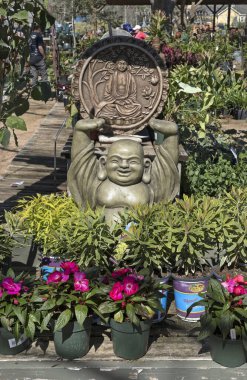 Greatwood, Teksas, ABD - 5 Mart 2023: Yerel bir bitkinin fidanlığında gülümseyen mutlu Buda heykeli