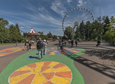 Saint Petersburg, Russia - July 12, 2023: Inside city's largest amusement park Divo Island. Brightly colored asphalt shows people where to walk. clipart
