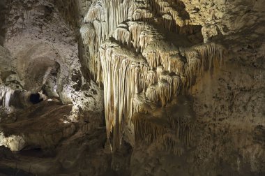 Cave flowstone hangs downward, create curtain-like sheaves along ledges, better known as draperies.Carlsbad Caverns National Park, New Mexico, USA. clipart