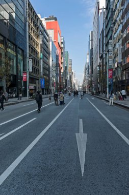 Tokyo, Japonya - 15 Aralık 2023: Ginza Caddesi trafiğin olmadığı bir alışveriş alanıdır. Dükkanlar, caddenin kenarlarında gökdelenlerin arka planına karşı dizilmiş..