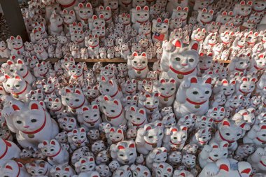 Şanslı kedi figürlerinden oluşan büyük bir grup. Tokyo, Japonya 'daki Gotoku-ji tapınağı..