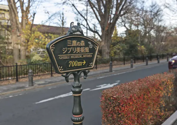 stock image Mitaka, Japan - December 18, 2023: Road sign showing the way to the Ghibli museum. Totoro mascot emblem decorates the sign.