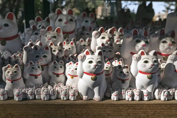 stock image Big and small lucky cats figurines waving their paws at visitors. Gotoku-ji temple in Tokyo, Japan.