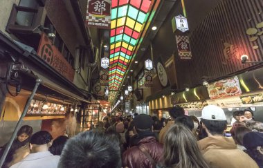 Kyoto, Japonya - 26 Aralık 2023: İnsanlar Nishiki pazarının ana caddesi boyunca kalabalık bir kalabalık içinde yürüyorlar.