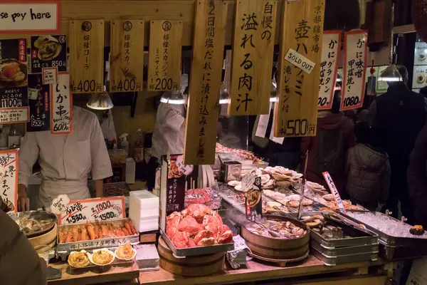 stock image Kyoto, Japan - December 26, 2023: Grilled seafood for sale at the  Nishiki market. Japanese snacks - clams, shrimp, scallop, squid.