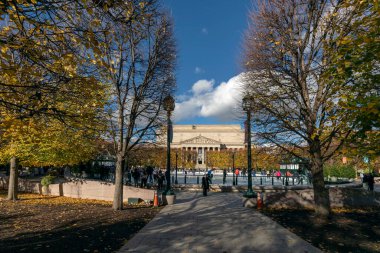 Washington, D.C., ABD - 29 Kasım 2024: Ulusal Sanat Heykel Bahçesi Galerisi 'ndeki buz pateni pisti. Manzaralı bir atmosferi olan küçük, rahat bir pist. Arka planda Ulusal Arşiv Binası.