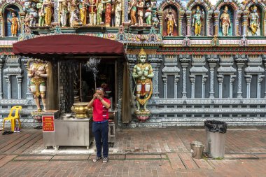 Singapur, Singapur Cumhuriyeti - 26 Aralık 2024: Bir adam Sri Krishnan Tapınağı girişinin önünde tütsü çubuklarıyla dua ediyor. Singapur 'un en eski Hindu tapınaklarından biridir..