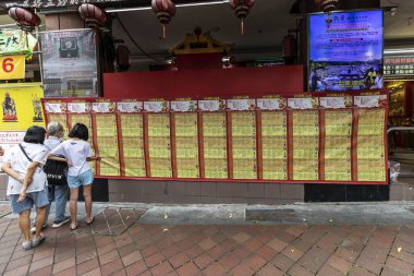 Singapur, Singapur Cumhuriyeti - 26 Aralık 2024: İnsanlar sokakta Çince takvim tahminlerini okuyor. 12 Çin burcu işareti.