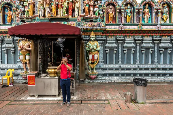 Singapur, Singapur Cumhuriyeti - 26 Aralık 2024: Bir adam Sri Krishnan Tapınağı girişinin önünde tütsü çubuklarıyla dua ediyor. Singapur 'un en eski Hindu tapınaklarından biridir..