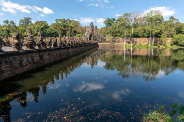 Angkor Thom, Kamboçya - 30 Aralık 2024 Angkor Thom Güney Kapısı. Angkor 'un yansımaları. Hendeğin üzerindeki köprüde eski muhafızlar var..