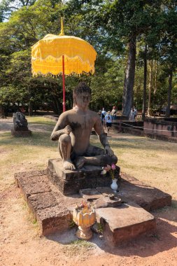 Angkor Thom, Kamboçya - 30 Aralık 2024: Angkor Arkeoloji Parkı, Kamboçya 'da altın tören şemsiyesi ve tütsü sunan Antik Khmer Buda heykeli.