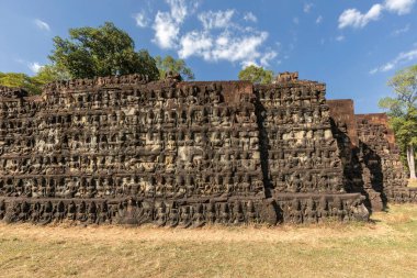 Angkor Thom, Kamboçya - 30 Aralık 2024: Angkor Thom 'da cüzzamlı kralın terası, Hindu tanrıları ve mitolojik figürleri tasvir eden karmaşık taş oymalar ve yardım heykelleri.