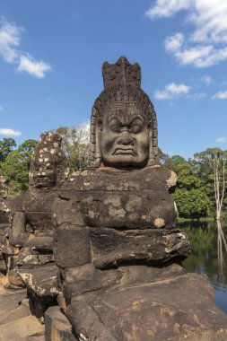 Angkor Thom, Kamboçya - 30 Aralık 2024 Angkor Thom Güney Kapısı 'ndaki antik koruyucu heykel. Yuvarlak gözlü ve buruşuk yüzlü Asuraları tasvir eden taş devleri..