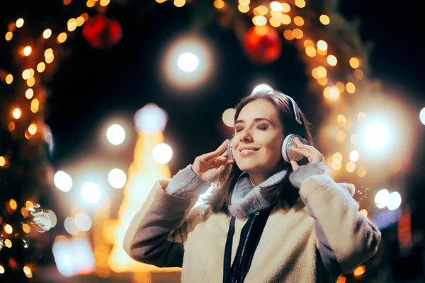 幸せな女性はクリスマスのイブにキャロルの屋外で聞く — ストック写真
