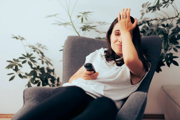 Forgetful Woman Holding a Remote Control Trying to Watch TV Show