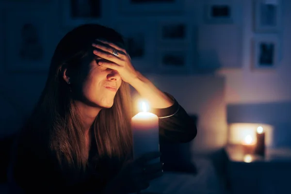 Stressed Woman Holding a Candle in Blackout No Power Situation