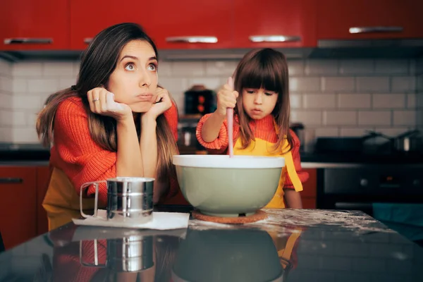 Stressed Mom Supervising her daughter in the Kitchen Cooking