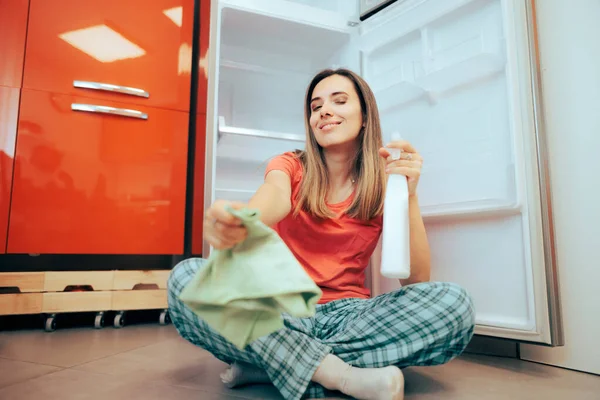 Happy Woman Trying to Clean Her Fridge Using Detergent and Cloth