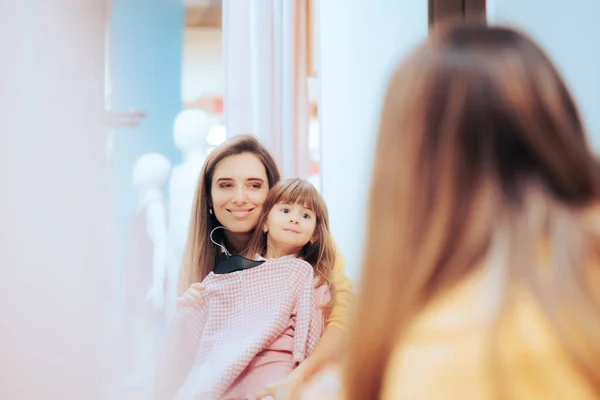 Mother and Daughter Buying Clothes Looking in the Mirror