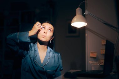 Woman Working at the Computer During Nighttime Using Eye Drops