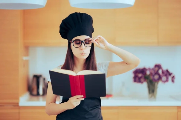 Γυναίκα Κρατώντας Ένα Βιβλίο Μαγειρικής Έλεγχος Έξω Μια Συνταγή — Φωτογραφία Αρχείου