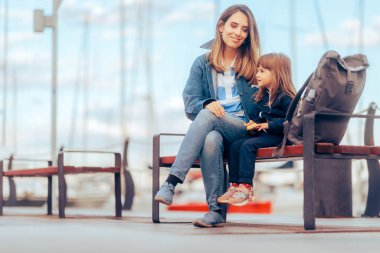 Anne ve Kızı Turistik Limanda bir bankta yan yana oturuyorlar.  