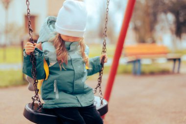 Kendi kendine oynayan mutsuz küçük kız. 