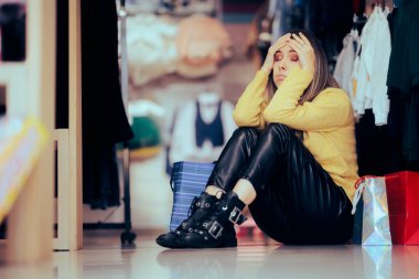 Stresli Alışverişçi Mağaza zemininde oturmaktan yorgun düşüyor 