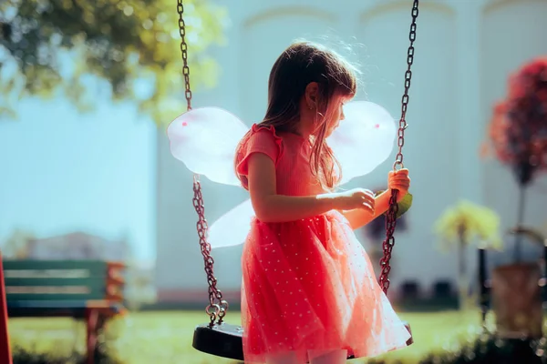Gadis Kecil Memakai Sayap Peri Bermain Dalam Ayunan Playground — Stok Foto