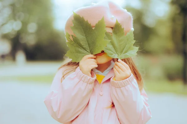 スタイリッシュなベレー帽をかぶった女の子2枚の緑の葉 — ストック写真