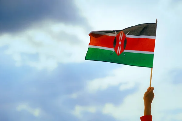 Hand Waving the Flag of Kenya on the Sky