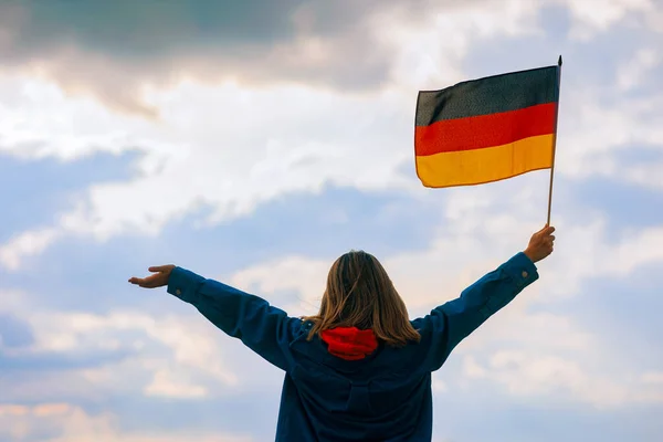 女子摇曳德国国旗望着天空 — 图库照片