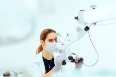 Hastaları tedavi etmek için Dişçi Mikroskop Aracı Kullanıyor. 