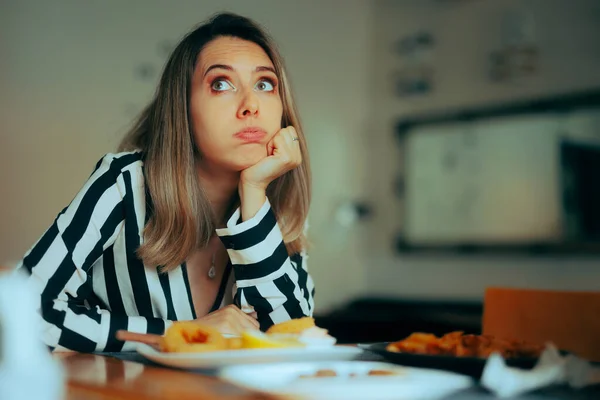 厌倦了的女人坐在餐馆里而不是吃她的食物 — 图库照片
