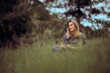 Çimenlerde oturan kadın Dışarıda dinleniyor 