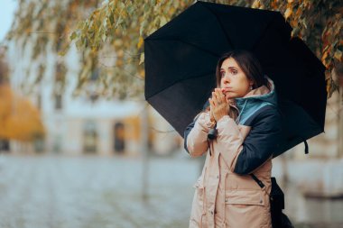 Ellerimi ovuşturan kadın Yağmurlu bir günde üşüyor