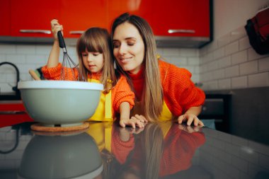 Anne kızına evde kurabiye yapmayı öğretiyor. 