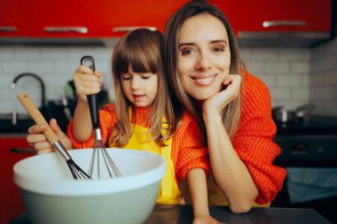 Anne kızına evde kurabiye yapmayı öğretiyor. 