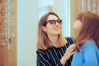 Anne, Küçük Lamba Mikroskobuyla Göz Muayenesi sırasında Çocuğa Yardım Ediyor