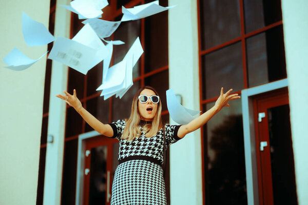 Carefree Businesswoman Throwing Documents outside Office Building