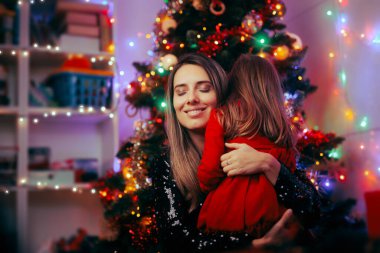 Neşeli anne kızını kucaklıyor Noel 'i birlikte kutluyor. 