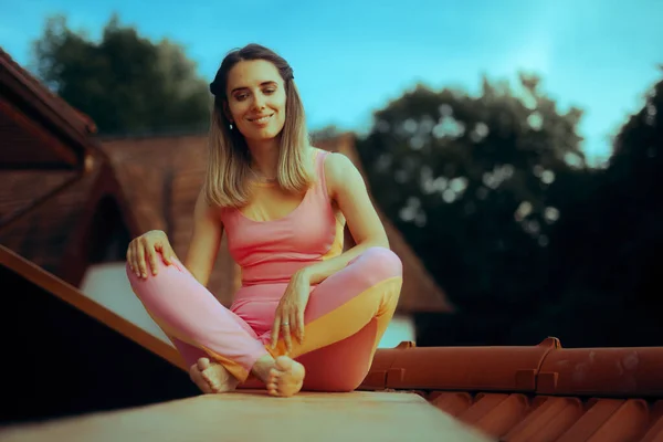 Woman Wearing Sportwear bra and Leggings Sitting on a Rooftop