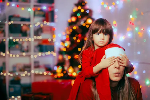 Girl Covering the Eyes of her Mom for a Christmas Surprise