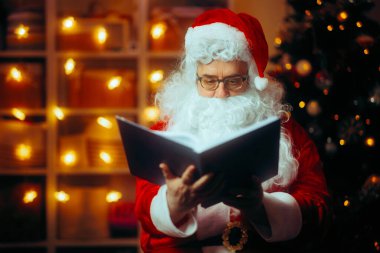 Noel Baba elinde Noel Masalları Okurken Bir Kitap Tutuyor