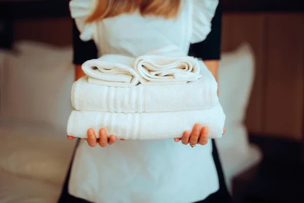 Hands of a Maid Holding Fresh Towels in a Hotel Room
